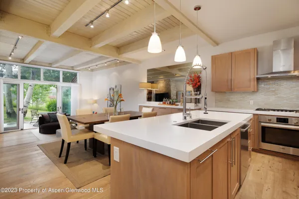 a kitchen with a sink and chairs