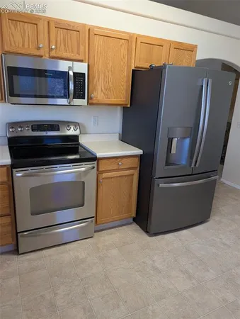a kitchen with granite countertop white cabinets and stainless steel appliances