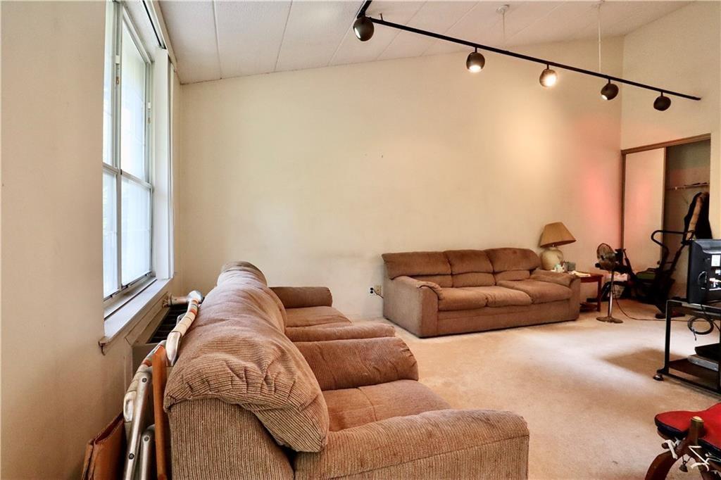 9967 Shore Road, Unit 7E Brooklyn, NY 11209 - Photo 11 of 19 a living room with furniture a couch and a flat screen tv