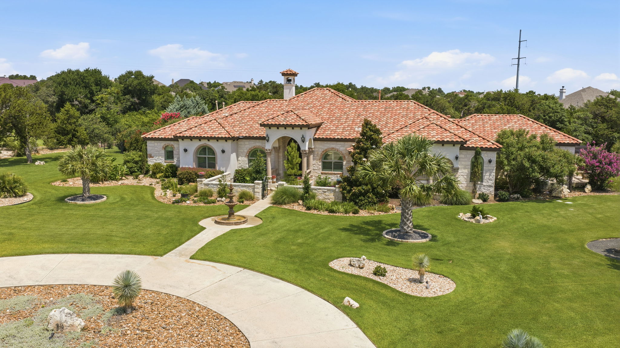 816 Brave Face Street Leander, TX 78641 - Photo 2 of 40 A terracotta-tiled roof crowns this residence, featuring a sweeping circular driveway and meticulously manicured lawns.