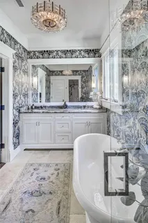 a spacious bathroom with a granite countertop sink a mirror and bathtub