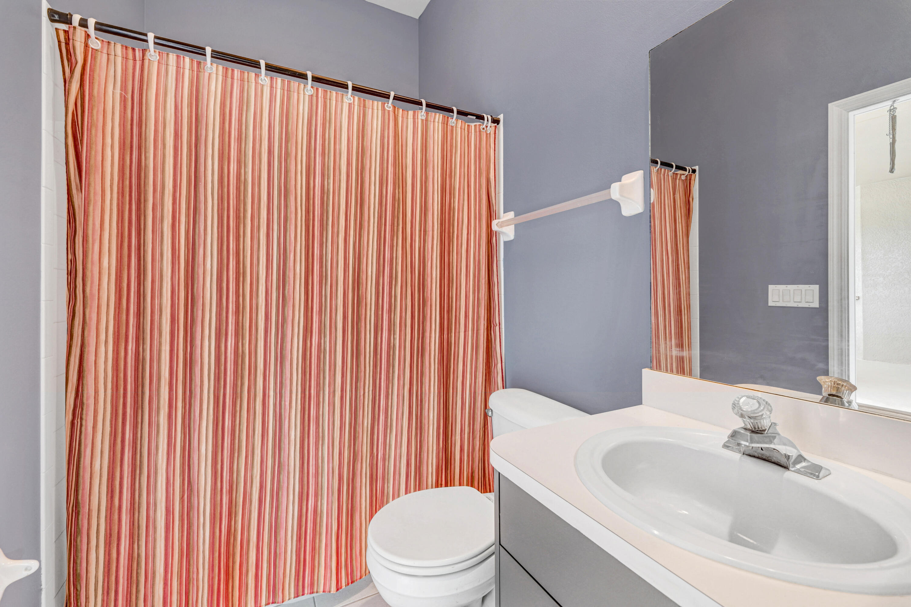 4600 James Road Cocoa, FL 32926 - Photo 31 of 56 a bathroom with a sink a toilet and shower curtain