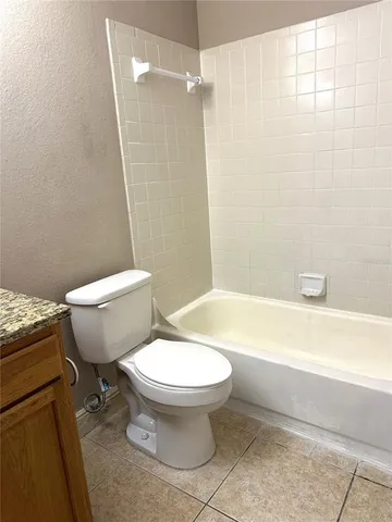 a white toilet sitting next to a bath tub and a shower