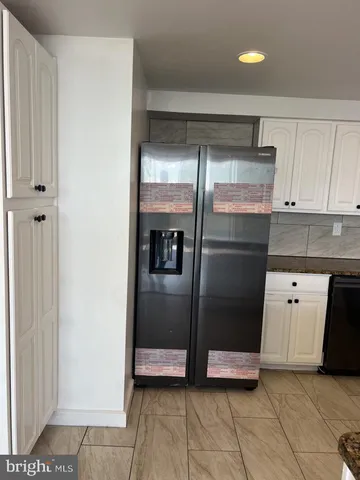 a kitchen with granite countertop white cabinets and stainless steel appliances