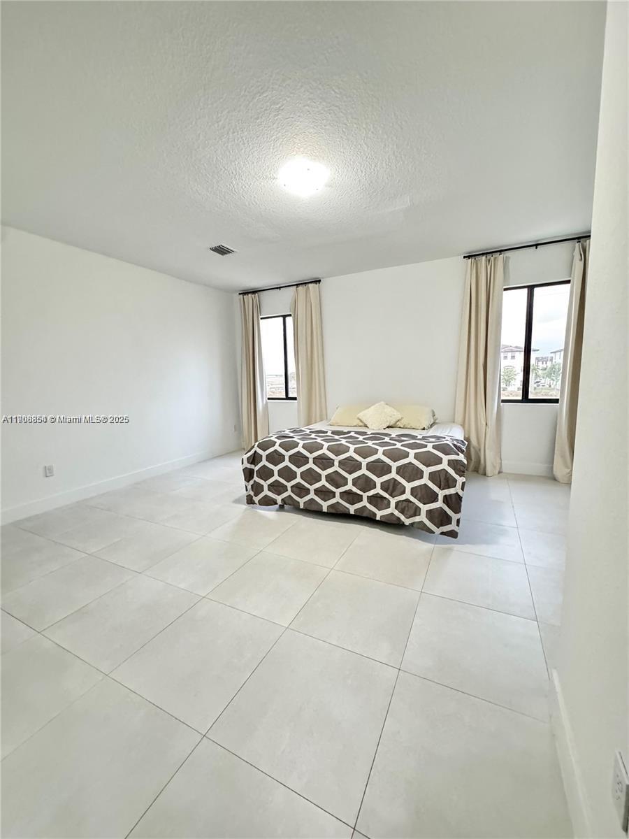 13627 Southwest 157th Court Miami, FL 33196 - Photo 17 of 26 a large white bed in a white room