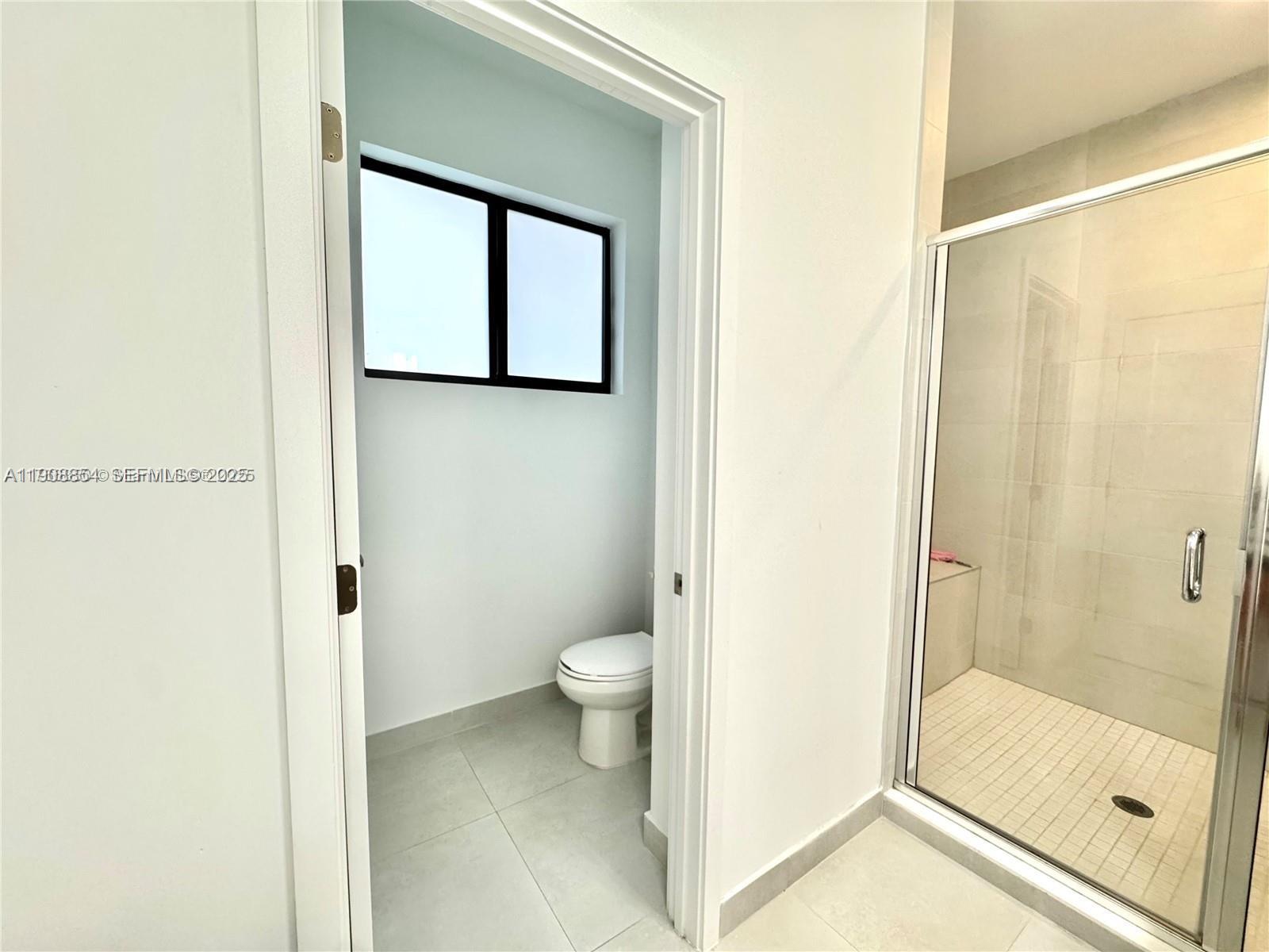 13627 Southwest 157th Court Miami, FL 33196 - Photo 21 of 26 a bathroom with a granite countertop toilet and a shower