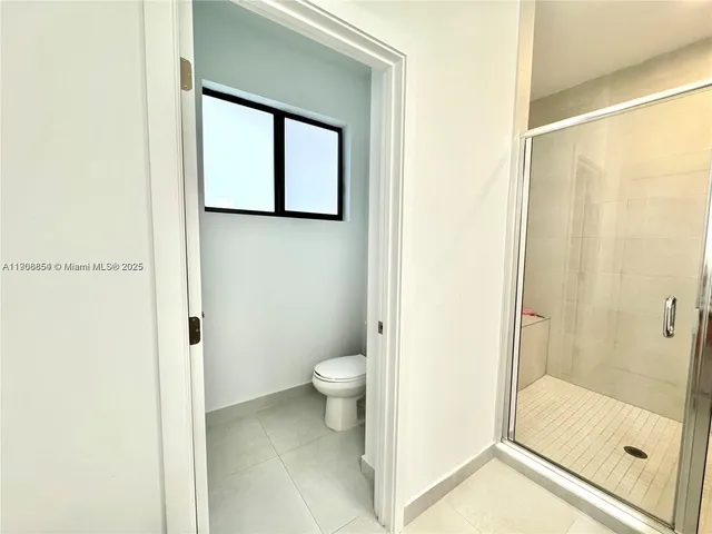 a bathroom with a toilet a sink and a large mirror