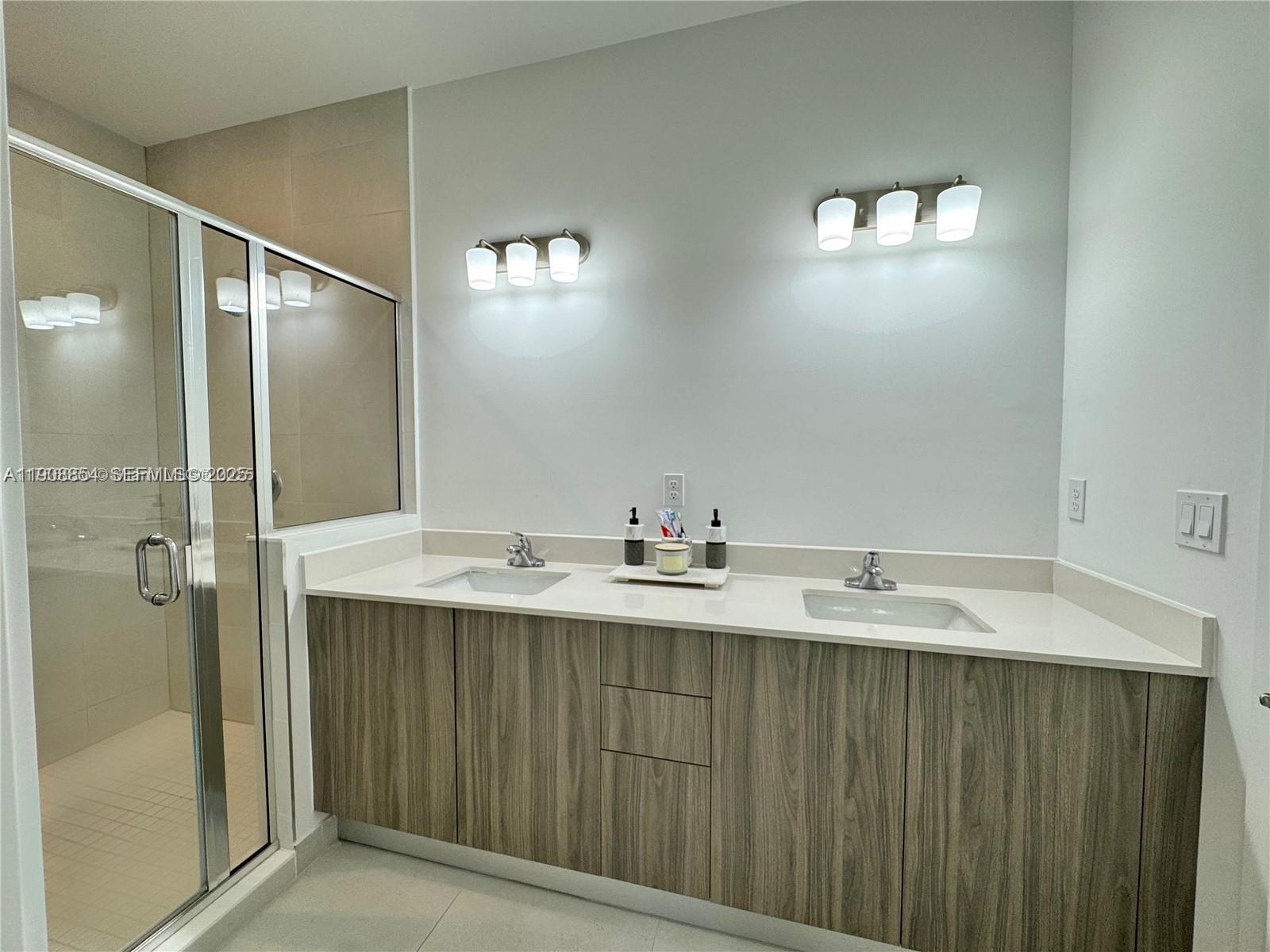 13627 Southwest 157th Court Miami, FL 33196 - Photo 22 of 26 a bathroom with a double vanity sink and mirror