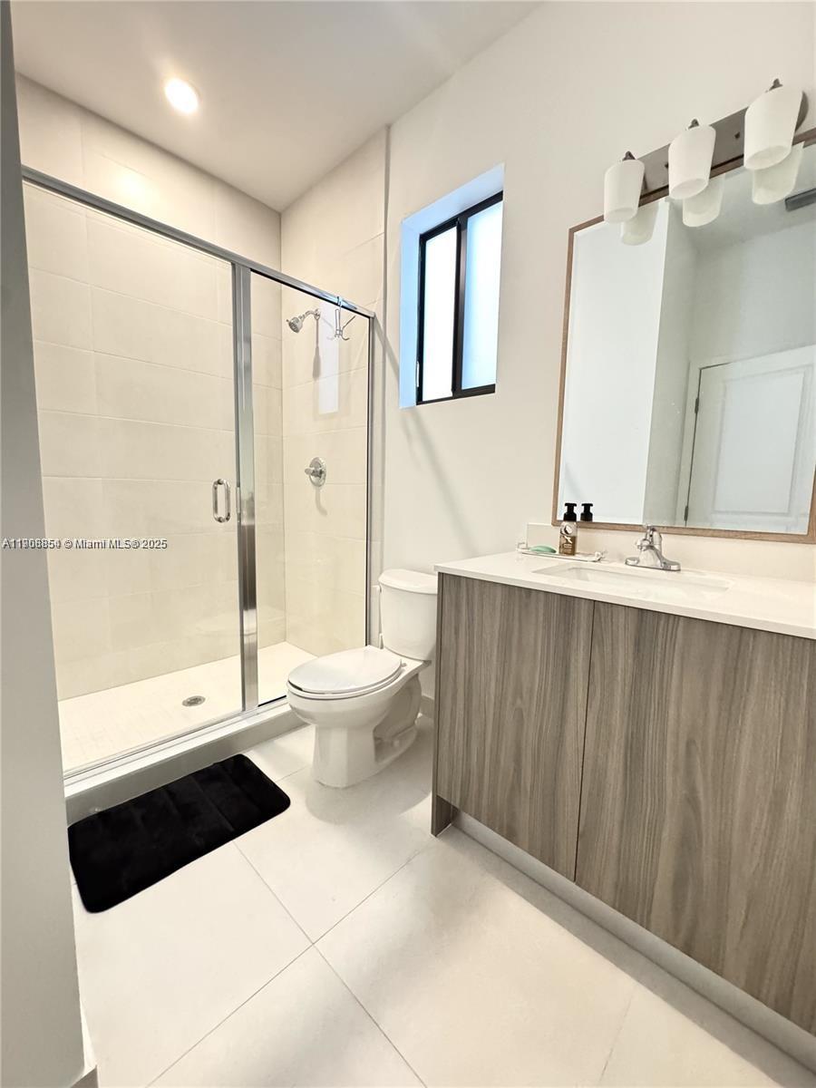 13627 Southwest 157th Court Miami, FL 33196 - Photo 23 of 26 a bathroom with a toilet a sink and a large mirror
