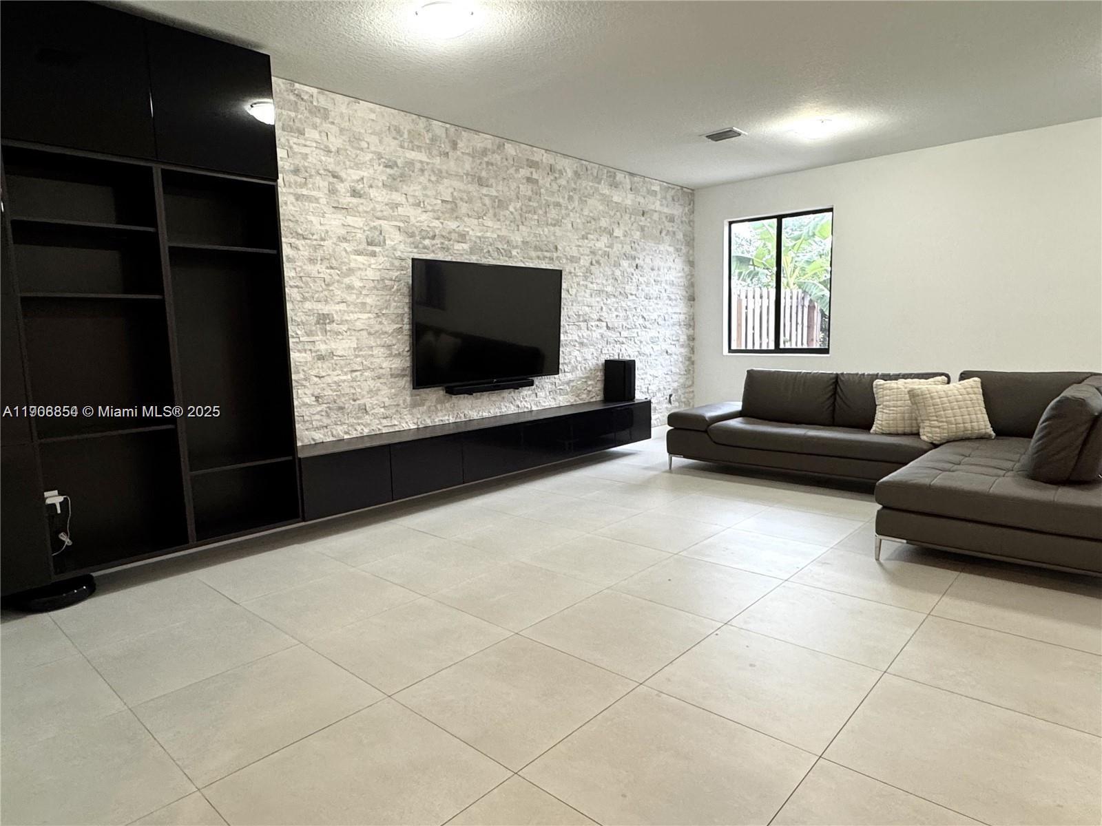 13627 Southwest 157th Court Miami, FL 33196 - Photo 4 of 26 a living room with furniture and a flat screen tv