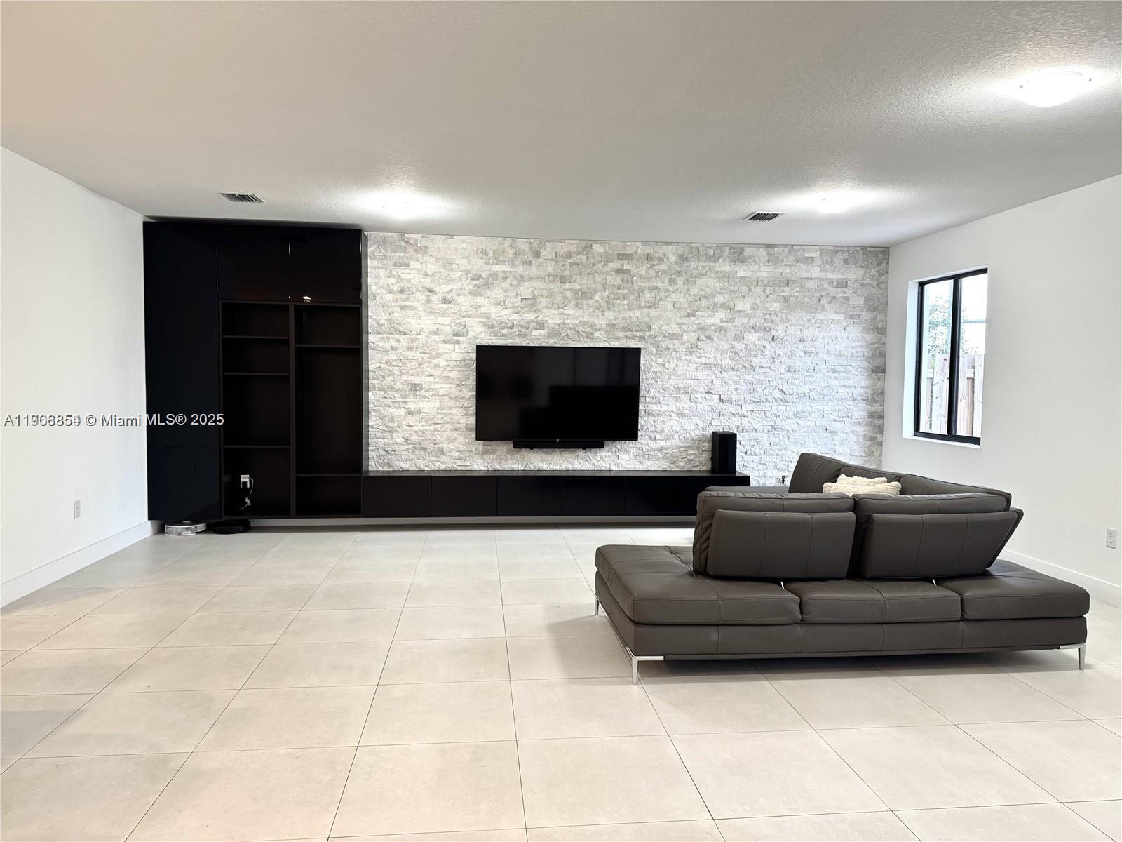 13627 Southwest 157th Court Miami, FL 33196 - Photo 5 of 26 a living room with furniture and a flat screen tv