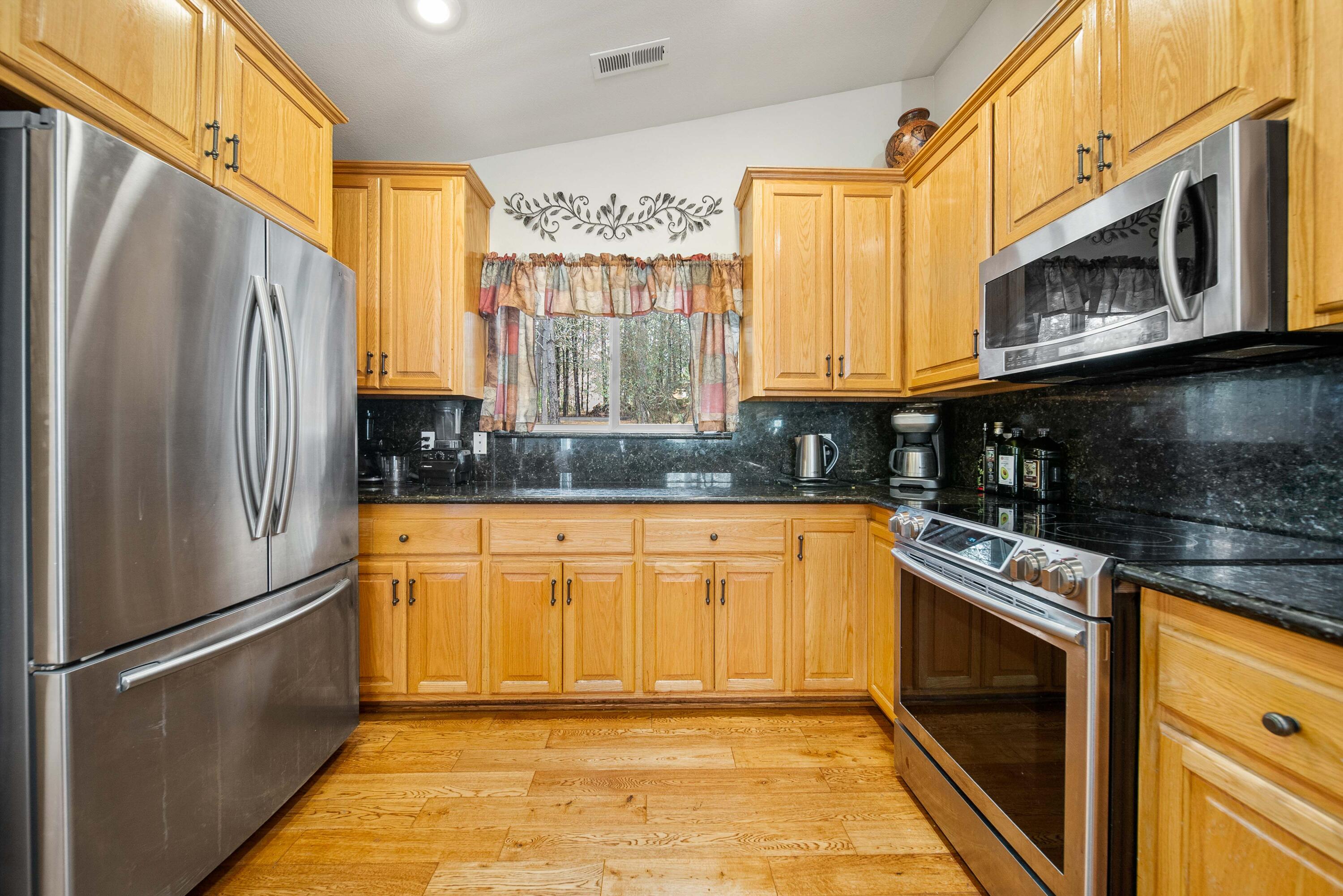 1280 Crow Road Merlin, OR 97532 - Photo 6 of 44 a kitchen with stainless steel appliances granite countertop a refrigerator a stove and a sink