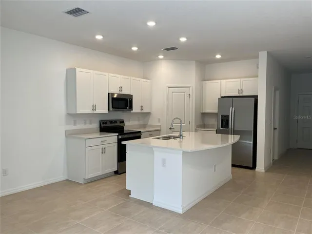 a kitchen with a sink stainless steel appliances and counter space