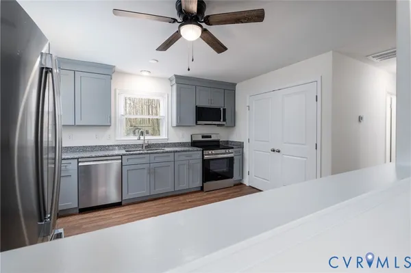 a kitchen with stainless steel appliances granite countertop a refrigerator a stove a sink and a microwave