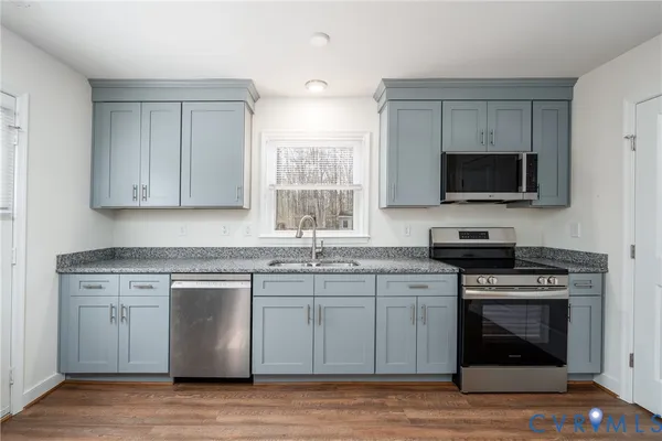 a kitchen with stainless steel appliances a stove a sink and a microwave