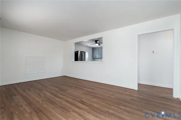 a view of a room with wooden floor and white walls