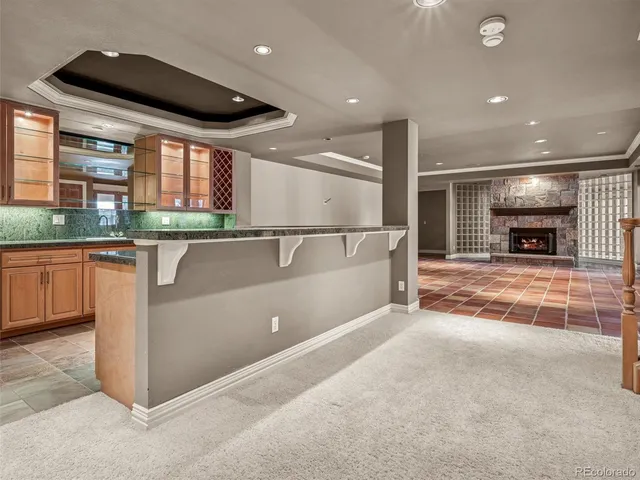 a large kitchen with granite countertop a sink and white cabinets