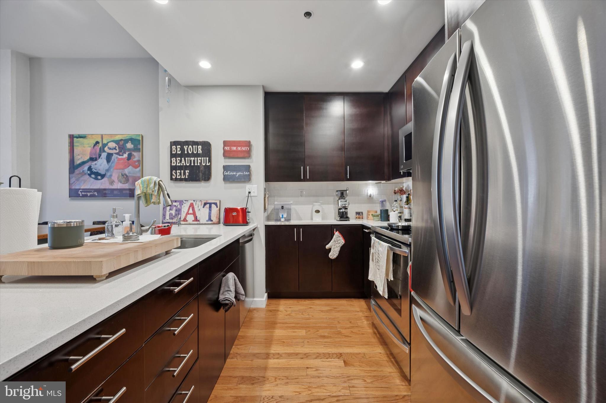 315 New Street, Unit 417 Philadelphia, PA 19106 - Photo 11 of 29 a kitchen with stainless steel appliances kitchen island granite countertop a refrigerator and a sink