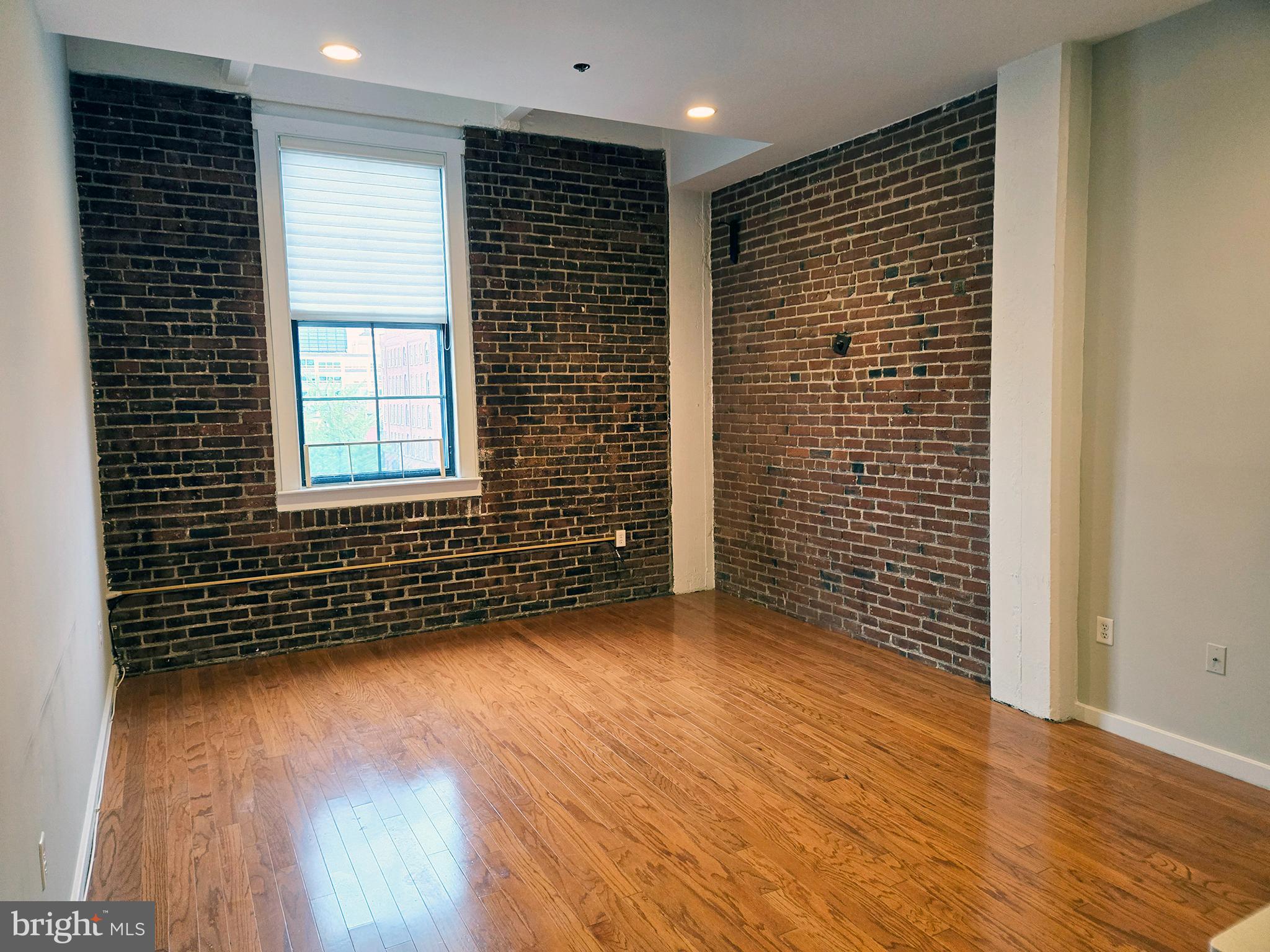 315 New Street, Unit 417 Philadelphia, PA 19106 - Photo 5 of 29 an empty room with wooden floor and a window