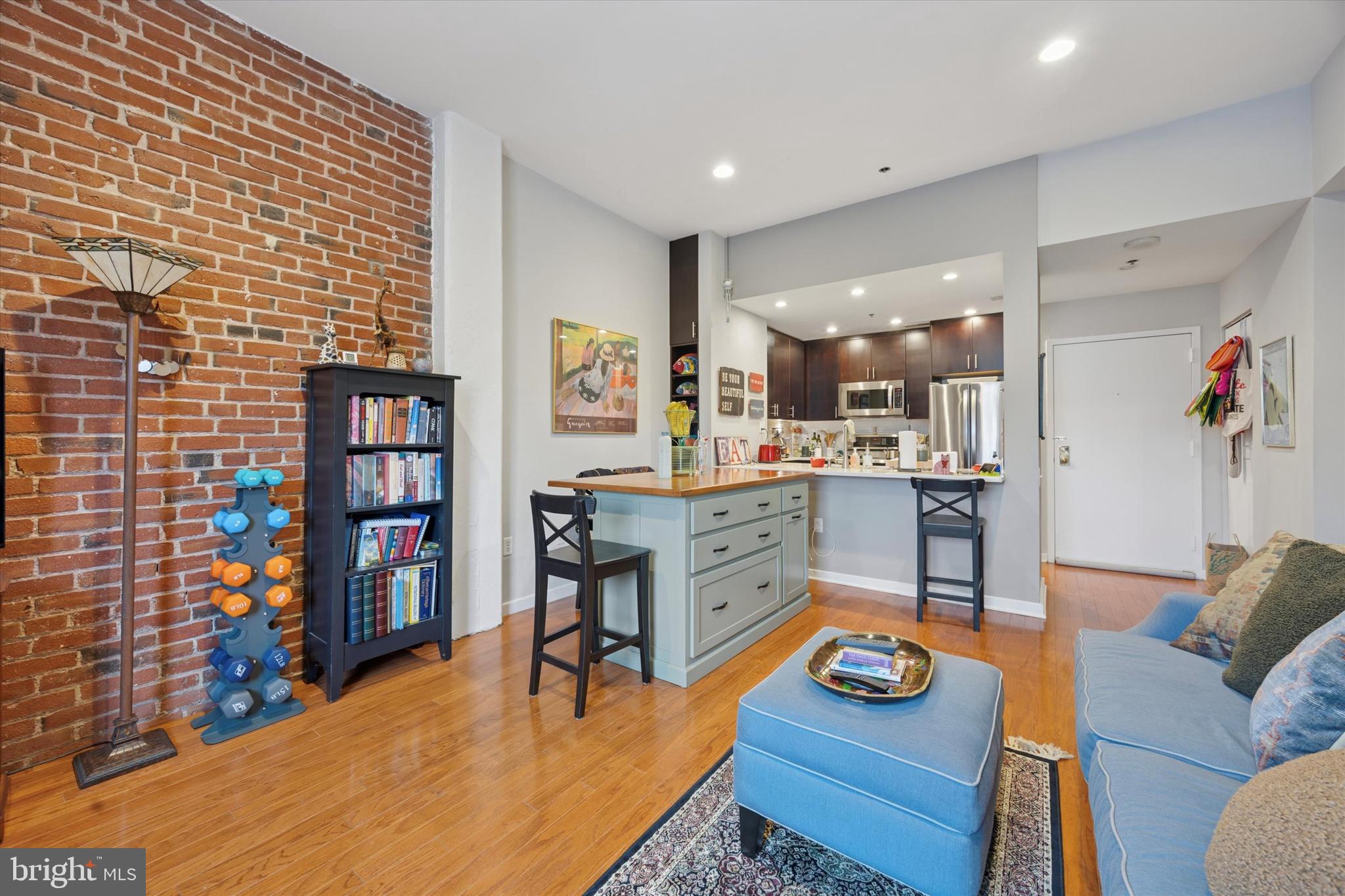 315 New Street, Unit 417 Philadelphia, PA 19106 - Photo 7 of 29 a living room with furniture and a dining table with kitchen view