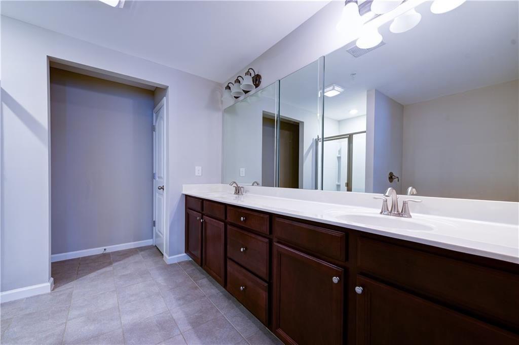 1226 Fischer Trace Cumming, GA 30041 - Photo 16 of 24 a bathroom with a double vanity sink and a mirror
