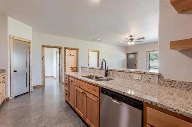 a kitchen with stainless steel appliances granite countertop a stove a sink and a refrigerator