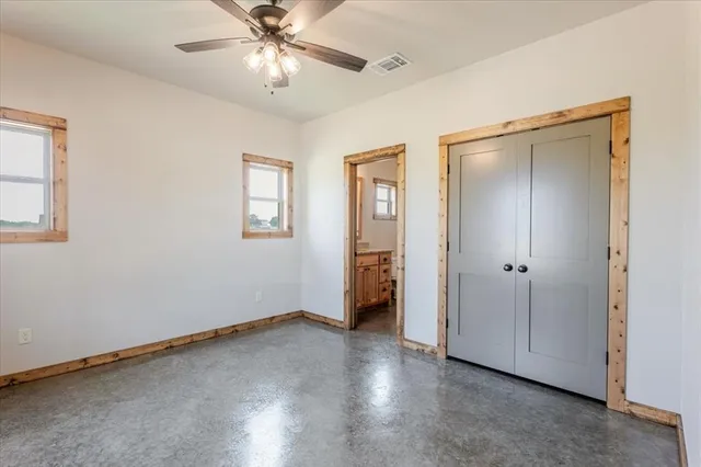an empty room with a window and a ceiling fan
