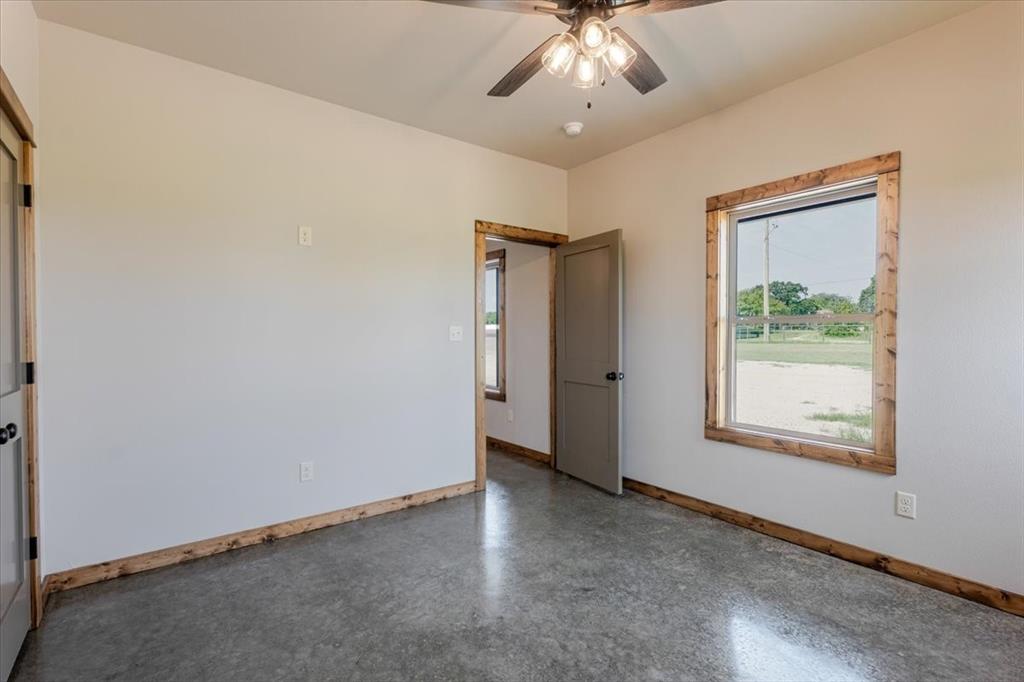 11 Maverick Loop Granbury, TX 76048 - Photo 16 of 27 an empty room with a window and a ceiling fan