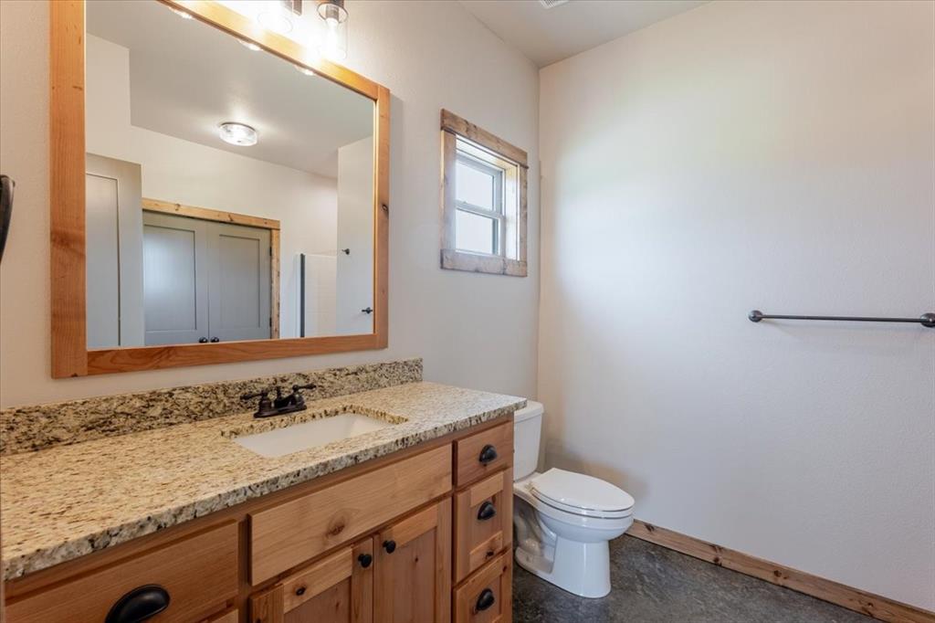 11 Maverick Loop Granbury, TX 76048 - Photo 17 of 27 a bathroom with a granite countertop sink toilet and mirror