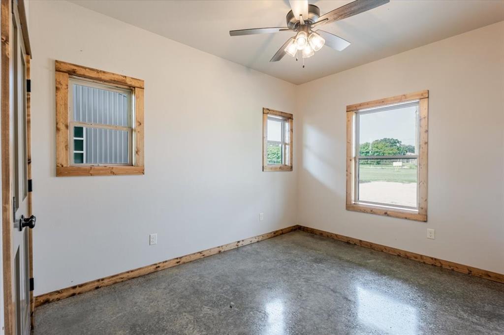 11 Maverick Loop Granbury, TX 76048 - Photo 19 of 27 an empty room with a window and a fan