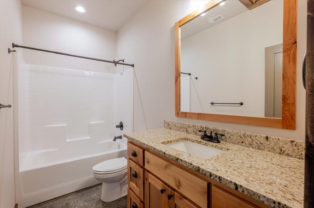 11 Maverick Loop Granbury, TX 76048 - Photo 21 of 27 a bathroom with a granite countertop sink toilet and shower