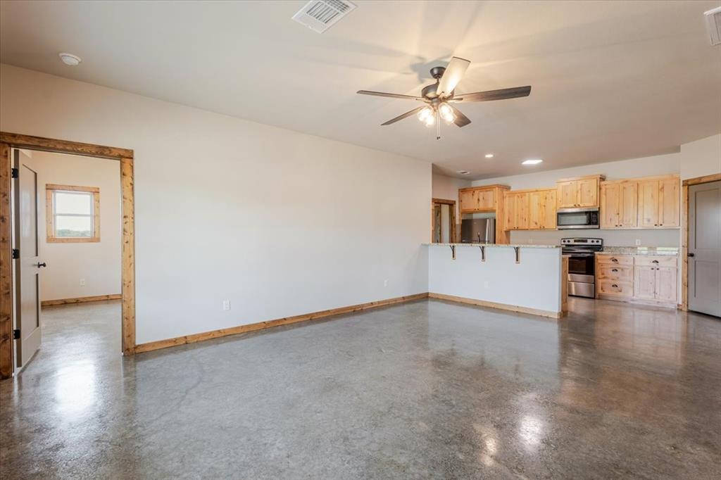 11 Maverick Loop Granbury, TX 76048 - Photo 7 of 27 a view of a livingroom with kitchen appliances and a ceiling fan