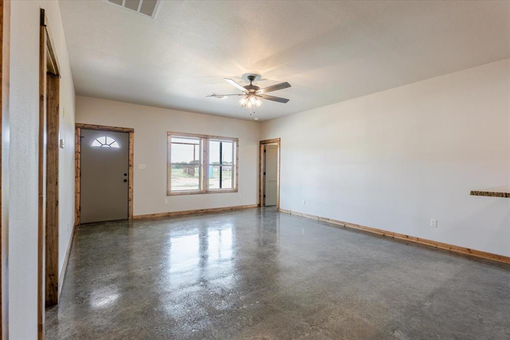 11 Maverick Loop Granbury, TX 76048 - Photo 8 of 27 an empty room with chandelier fan and windows