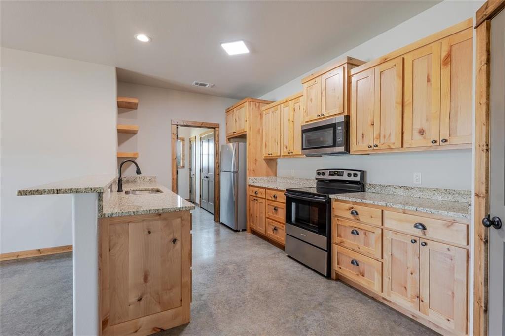11 Maverick Loop Granbury, TX 76048 - Photo 10 of 27 a kitchen with stainless steel appliances granite countertop a stove a sink and a refrigerator