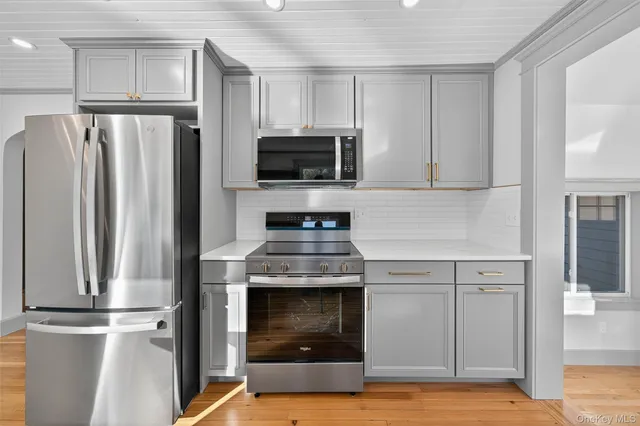 a kitchen with white cabinets and stainless steel appliances