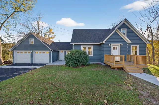 a view of a house with a yard and large tree