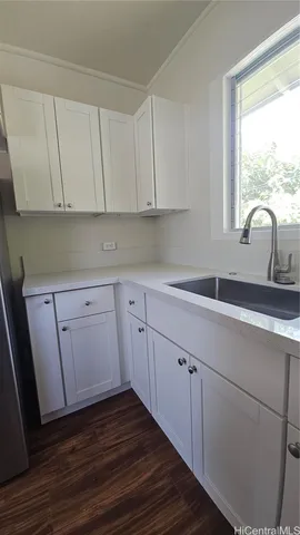 a kitchen with wooden cabinets a sink and dishwasher next to a window