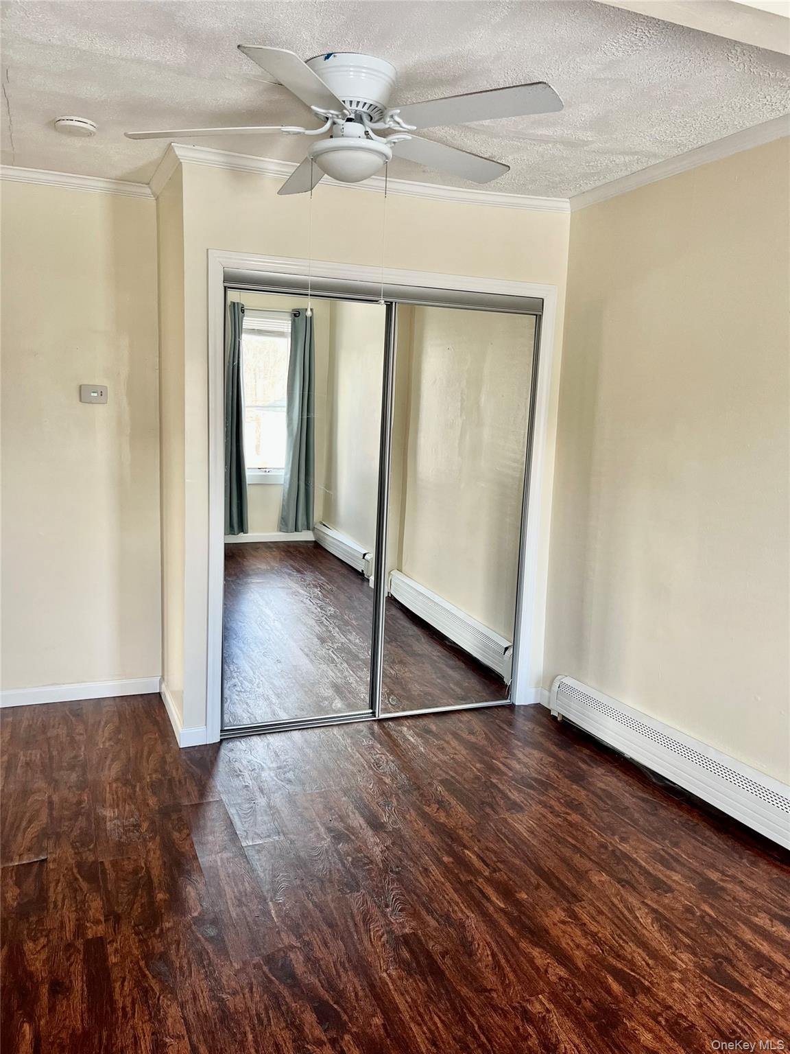 72 Lakeside Road Mahopac, NY 10541 - Photo 20 of 31 Unfurnished bedroom featuring a baseboard heating unit, dark wood-type flooring, a baseboard radiator, and crown molding