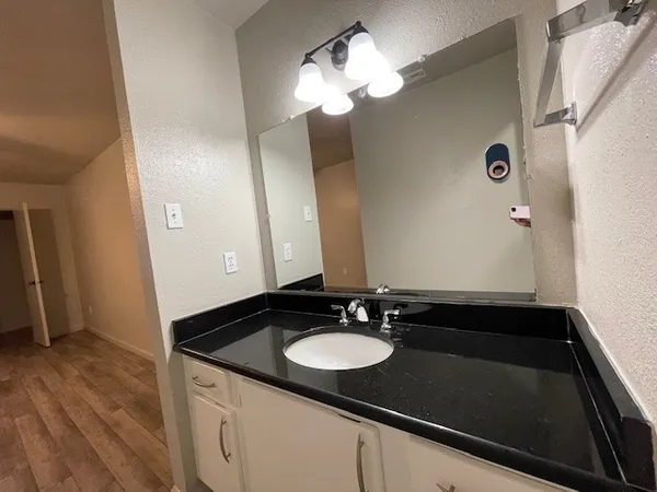 a bathroom with a sink vanity granite and a mirror