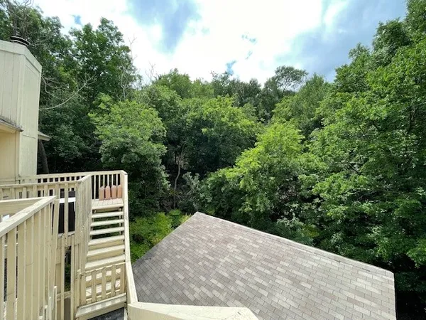 a view of a balcony with wooden floor and fence
