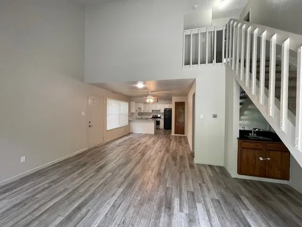 a view of a hallway with wooden floor and staircase