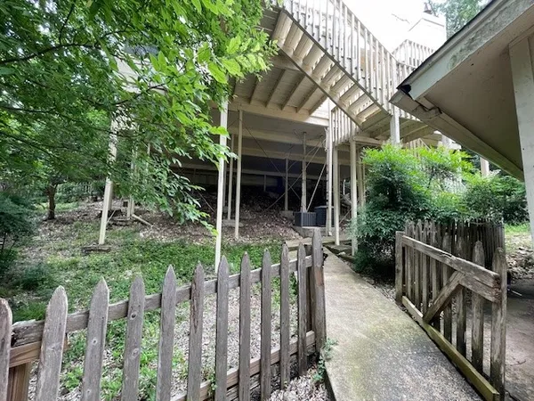 a view of small yard in front of house with wooden fence