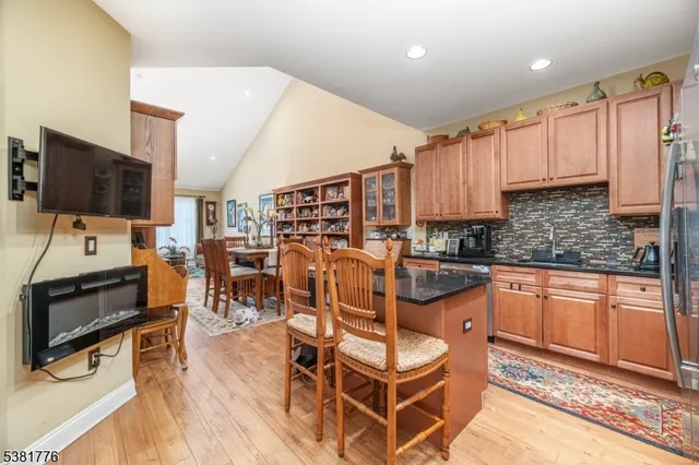 a kitchen with stainless steel appliances granite countertop a table chairs and a refrigerator