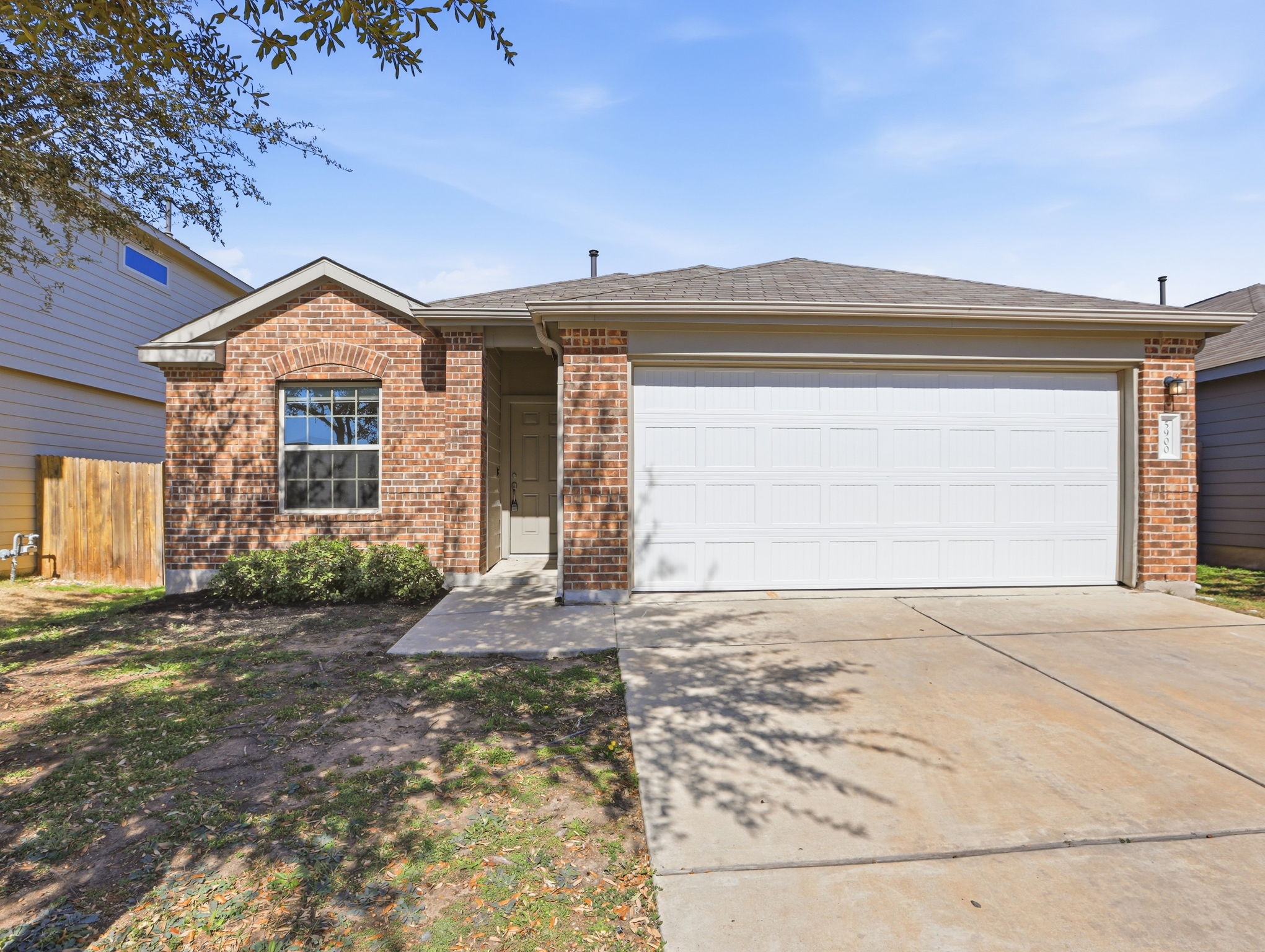 Ranch-style house featuring concrete driveway, a garage, and brick siding
