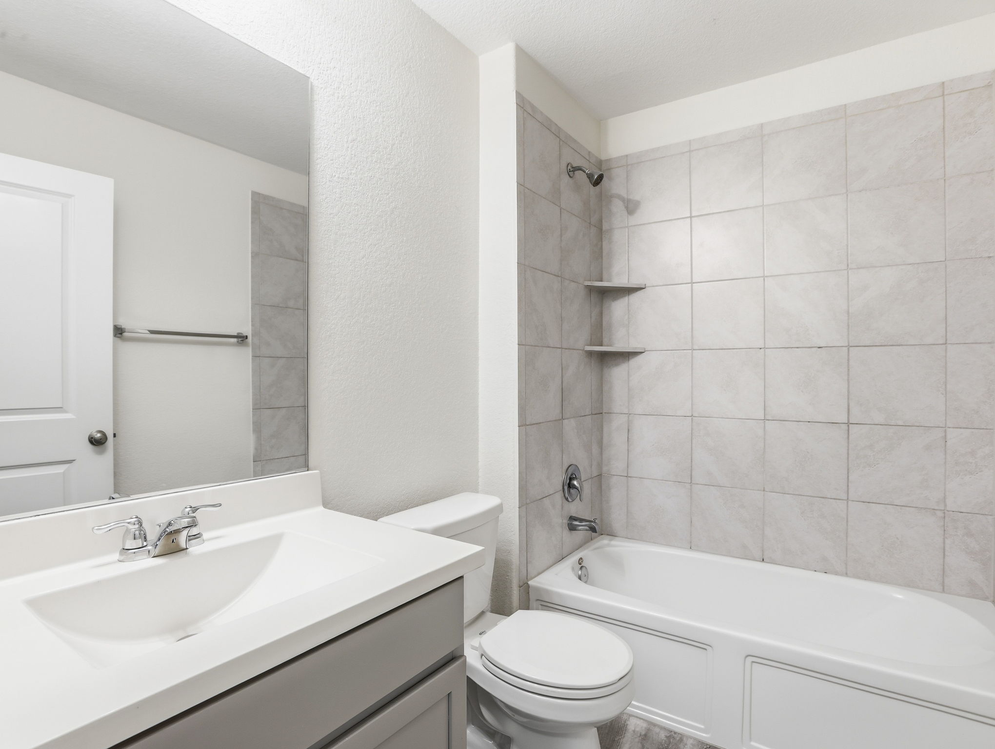 5900 Bell Tower Lane Austin, TX 78747 - Photo 20 of 26 Full bath with vanity, a textured wall, and bathtub / shower combination