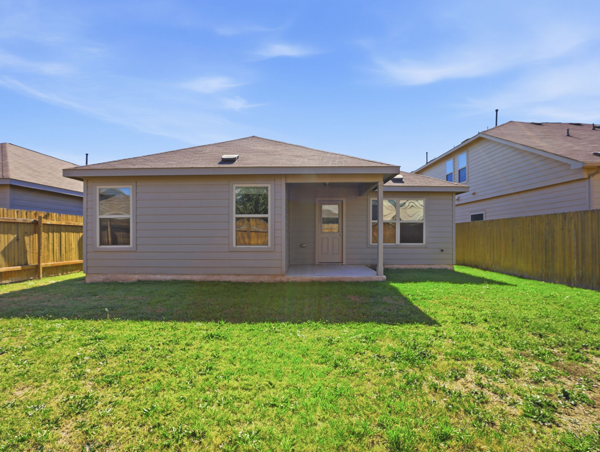 5900 Bell Tower Lane Austin, TX 78747 - Photo 24 of 26 Rear view of house with a patio, a fenced backyard, and roof with shingles