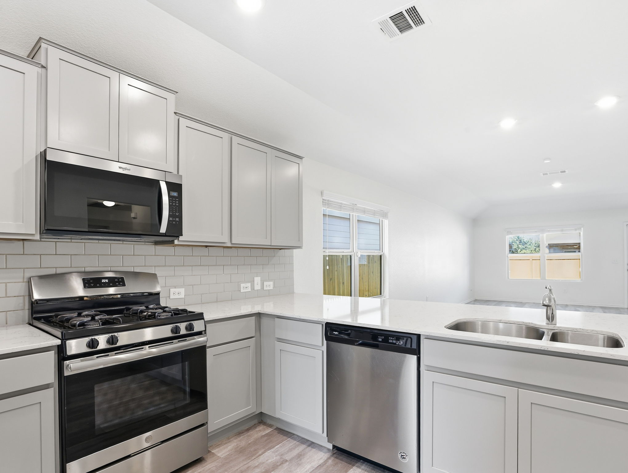 5900 Bell Tower Lane Austin, TX 78747 - Photo 4 of 26 Kitchen with stainless steel appliances, light wood-style flooring, recessed lighting, light stone countertops, and backsplash