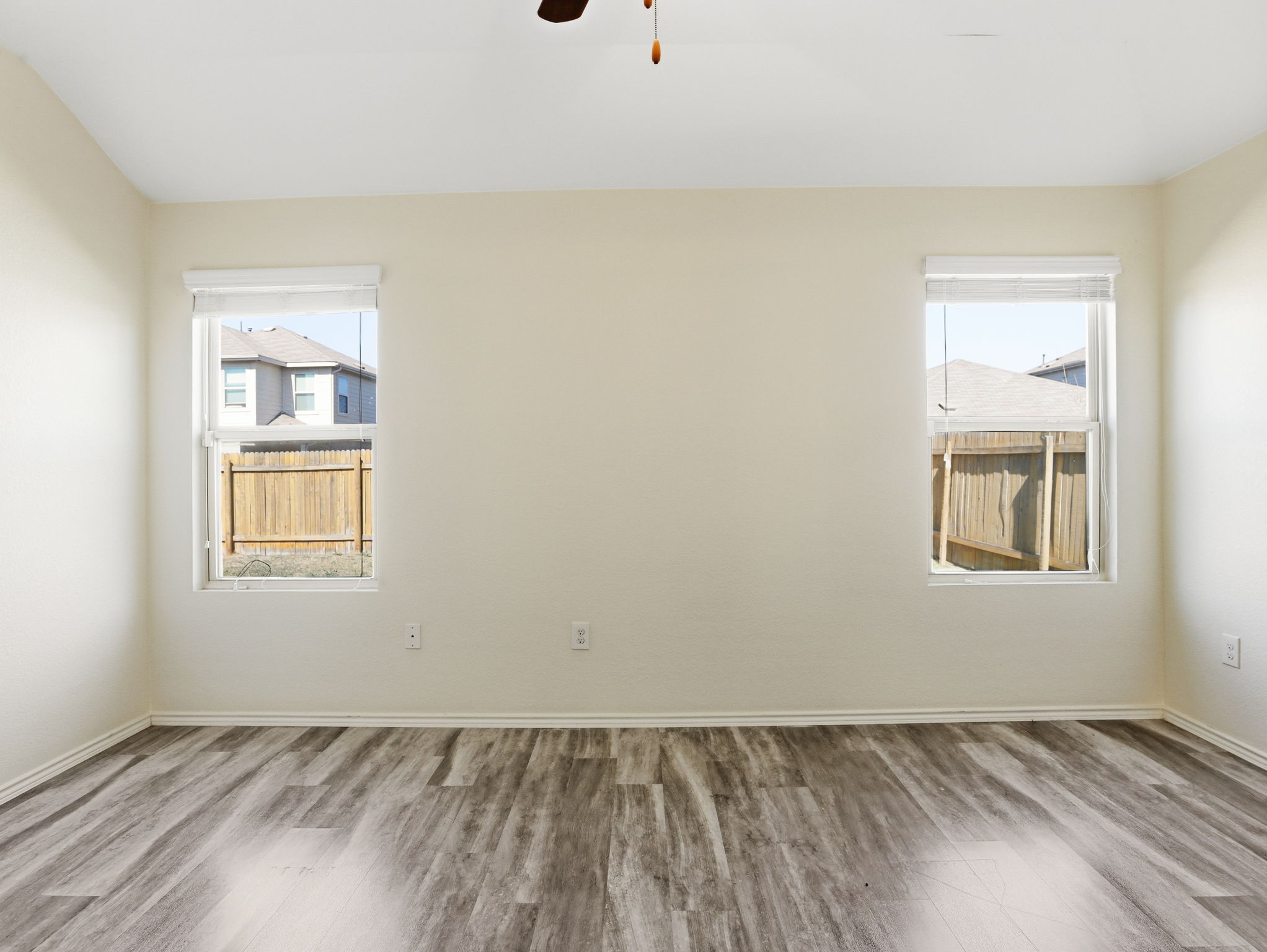 5900 Bell Tower Lane Austin, TX 78747 - Photo 7 of 26 Unfurnished room featuring wood finished floors and ceiling fan