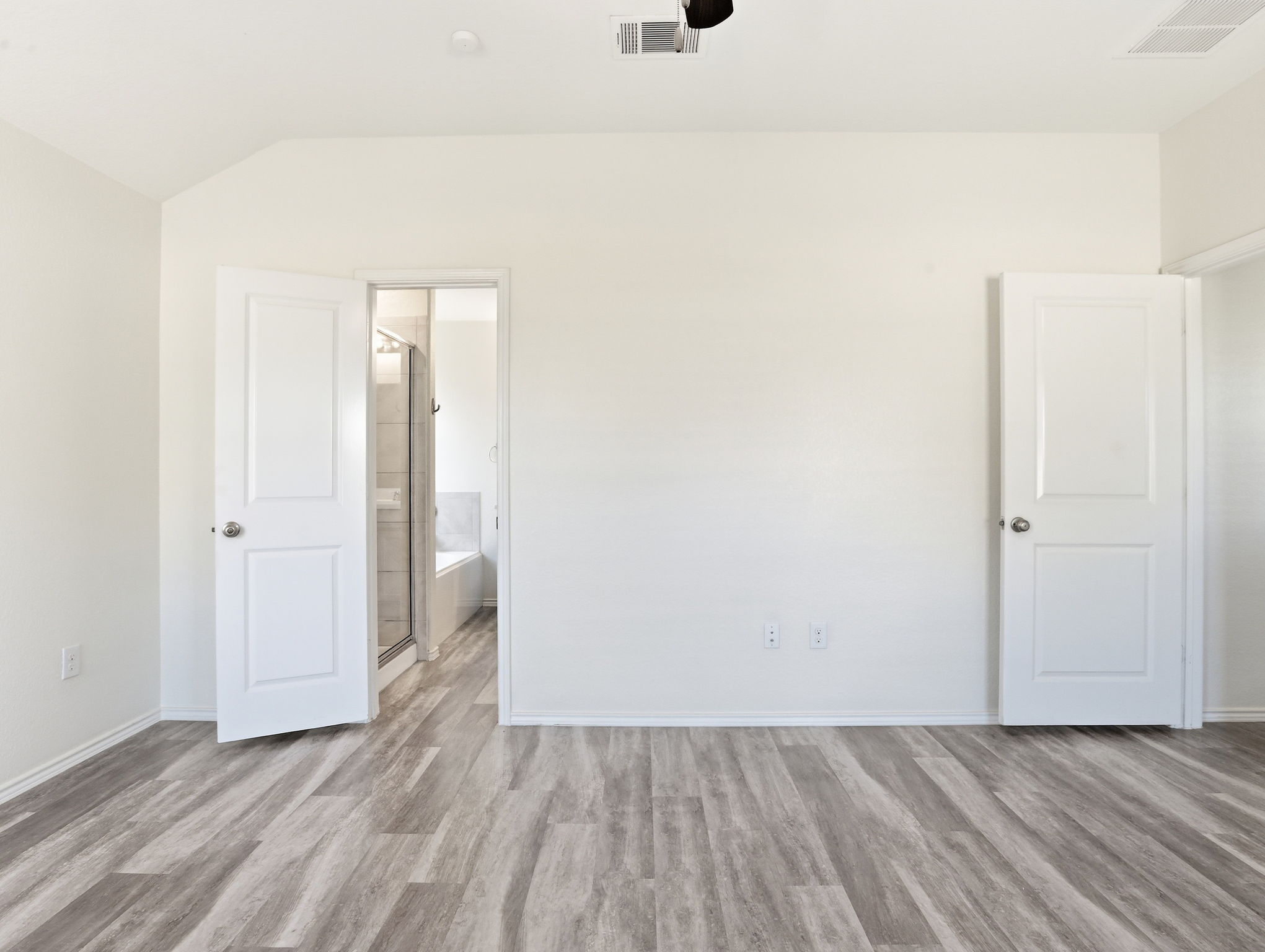 5900 Bell Tower Lane Austin, TX 78747 - Photo 8 of 26 Unfurnished bedroom with light wood-type flooring, a ceiling fan, lofted ceiling, and ensuite bath