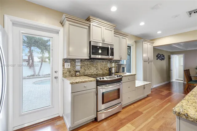 a kitchen with stainless steel appliances granite countertop a stove and a sink